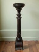 A large carved and stained wood pricket candlestick,