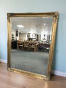 A large reproduction gilt and bevelled mirror, 107 cm x 137 cm.