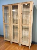 Three glazed pine cabinets, each 45 cm x 35 cm x 180 cm.