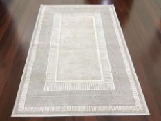 A contemporary machined cream rug, 180 cm x 120 cm.