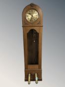 An early 20th century continental oak long case clock, with pendulum and weights, height 193 cm.