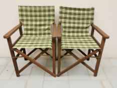 A pair of teak folding garden chairs.