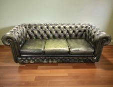 A 20th century green buttoned leather Chesterfield three seater club settee, 210 cm x 85 cm x 72 cm.