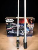 A Disney Star Wars The Force Awakens Millennium Falcon box set and two toy lightsabers.