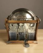 A Victorian oak and silver plate three bottle Tantalus, with key and decanters,