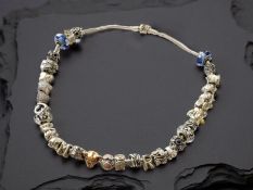 Pandora : A silver charm necklace strung with many decorative charms, length 44cm, in Pandora box.