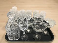 A group of crystal wine and champagne glasses, grapefruit dishes, decanter.