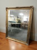 A large reproduction gilt and bevelled mirror, 110 cm x 140 cm.