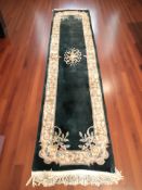 A Chinese woolen runner on dark green ground,
