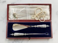 A cased silver-handled shoe horn and button hook, pearl necklace with silver clasp,