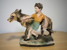 An Art Deco painted plaster figure group of a boy and a German shepherd, height 41 cm.
