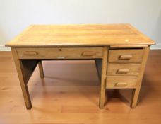 A 1920's oak single pedestal writing desk with retailers plaque 