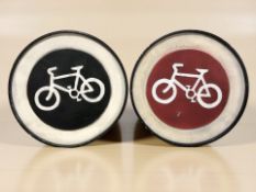 Two reproduction painted metal wall plaques depicting bicycles, diameter 50 cm.