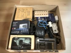 A box of various cameras, calligraphy pens,