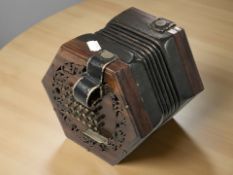 An early 20th century twenty four button concertina with pierced rosewood fret work,