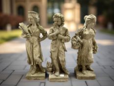 A weathered concrete garden statue of girl with basket of flowers and two further similar figures,