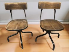 A pair of industrial machinist's style swivel chairs