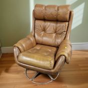 A 20th century studded tan leather and chrome swivel armchair,