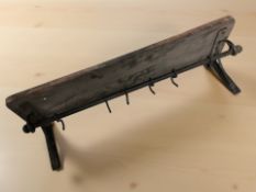 A wrought metal and wood coat rack,