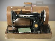 A Singer hand sewing machine in box