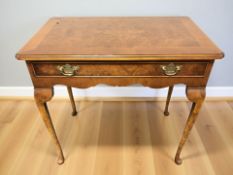 A reproduction yew wood side table on pad feet,