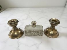 A pair of silver squat candlesticks, height 7 cm, together with an ornate metal-mounted scent flask.