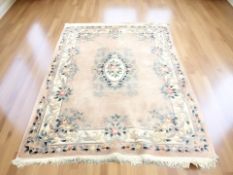 A Chinese woolen rug on peach ground,