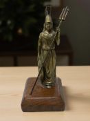 A bronze figure of Britannia holding a trident and shield on oak plinth, height 14.5 cm.