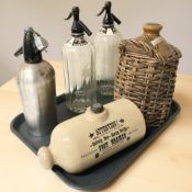 Two Schweppes soda water siphons, a further siphon,