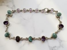 A silver bracelet with amethyst and turquoise stones,