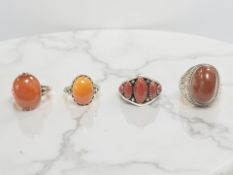 Two silver and amber rings, a similar yellow metal example,