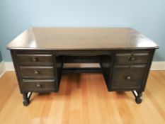 An Ercol stained elm twin pedestal desk, 140 cm x 77 cm x 73 cm.