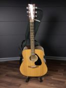 A Yamaha F-310 acoustic guitar, with soft carry bag and guitar stand.