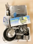 A quantity stainless steel cooking pans, colanders,