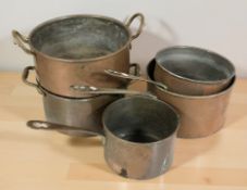 Three graduated saucepans and two further twin handled copper pans.