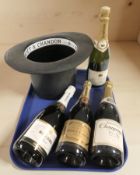 A Moet & Chandon plastic ice bucket in the form of a top hat, and four bottles of champagne.