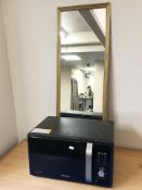 A Samsung microwave and a contemporary rectangular gilt mirror.