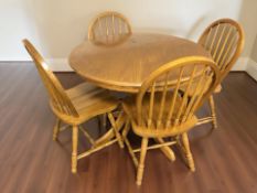 A contemporary circular dining table, diameter 100 cm, and a set of four spindle back chairs.