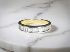An 18ct yellow gold baguette cut diamond half eternity ring, approximately 0.5ct, size L.