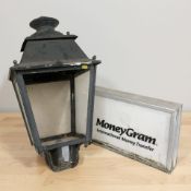 A money transfer shop sign, width 55 cm, and a street lantern.