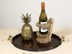 A brass ice bucket in the form of a pineapple, a carved wooden lizard bottle stand,