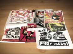 A group of unframed reproduction posters including Plasmatics, The Cramps, Carry On film posters,