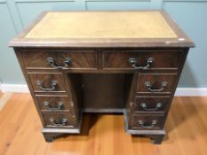 A reproduction mahogany knee hole writing desk with tooled leather inset top, 80 cm x 49 cm x 76 cm.