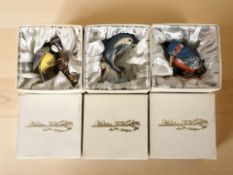Three Hidden Treasures enameled animal ornaments in boxes.