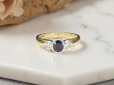 An 18ct yellow gold sapphire and two stone diamond ring, size M/N.