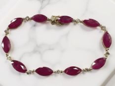 A 14ct yellow gold ruby and diamond bracelet, set with ten marquise-cut rubies (14.