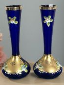 A pair of hand painted and gilt blue glass vases, height 20 cm.
