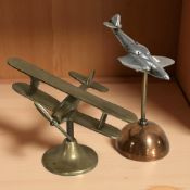 A brass desk model of a bi-plane and a further chrome Spitfire, height 18 cm.