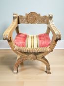 A 20th century savonarola style armchair, width 58 cm.