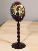 A decorative ostrich egg on stand, height 38 cm.